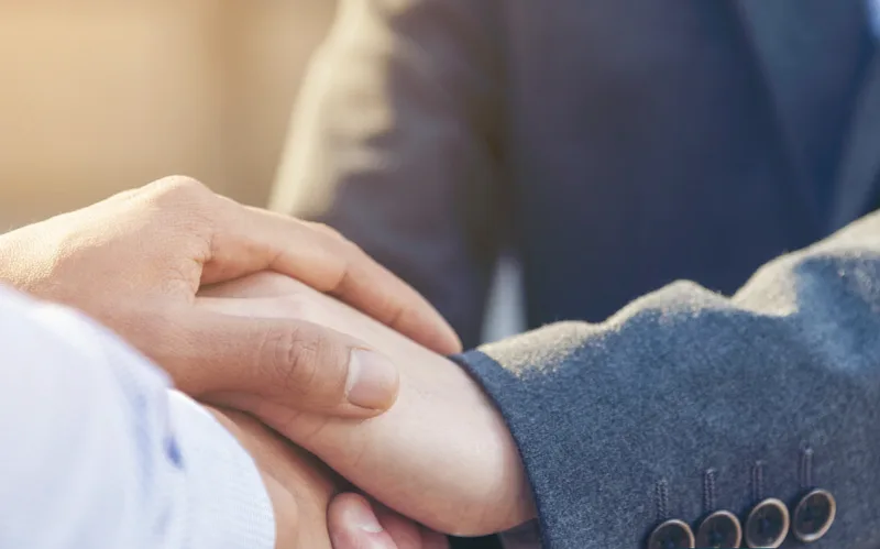 A professional greeting a client with a handshake