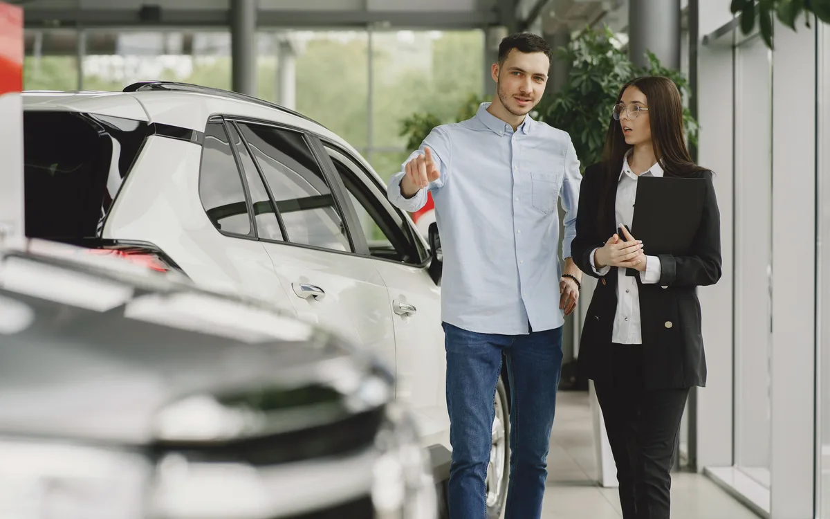 Illustrative stock: A car dealer assisting a customer in a showroom