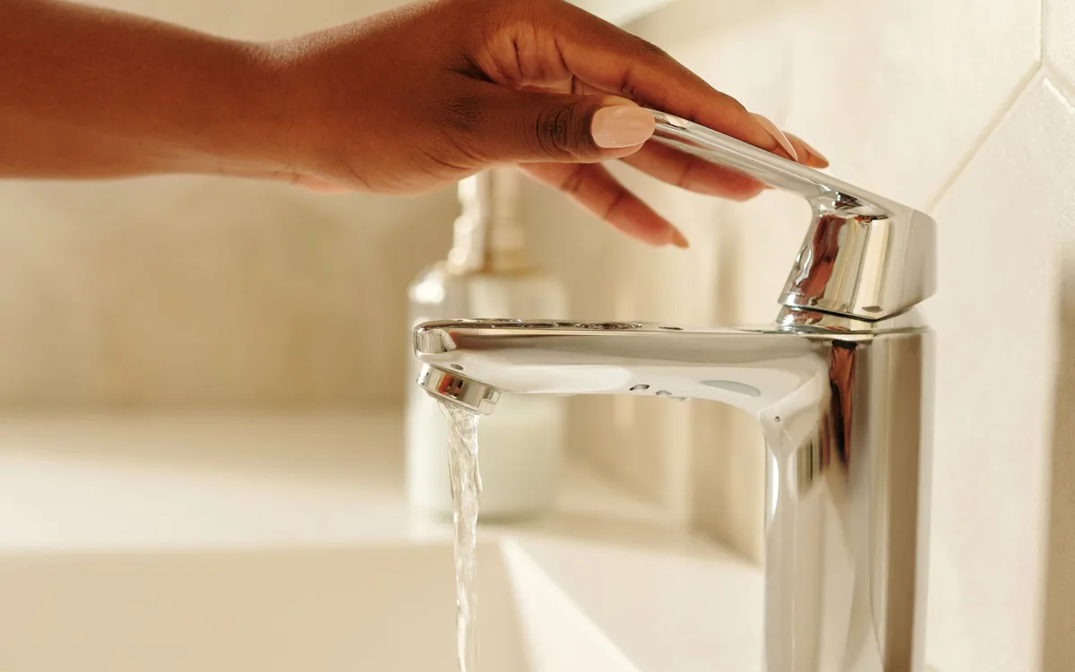 Illustrative stock: A person using a bathroom faucet